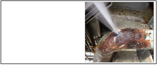 Corroded auxiliary feedwater pipe with hole in it and water spraying out 