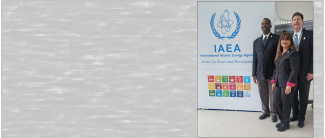 photo of three people in front of IAEA sign